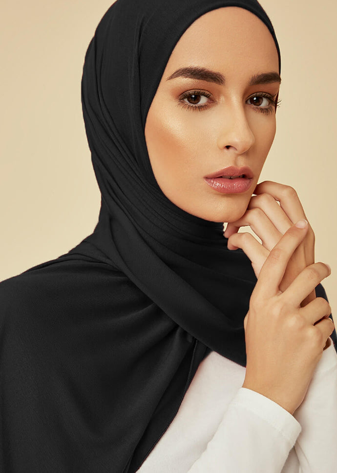Black colour. Effortless to style and incredibly comfortable to wear, with a subtle sheen. The medium-thick weight is soft, breathable, fully opaque and durable. Jersey works well in all climates, can be worn without an under scarf or pins, and makes a great option for working out.